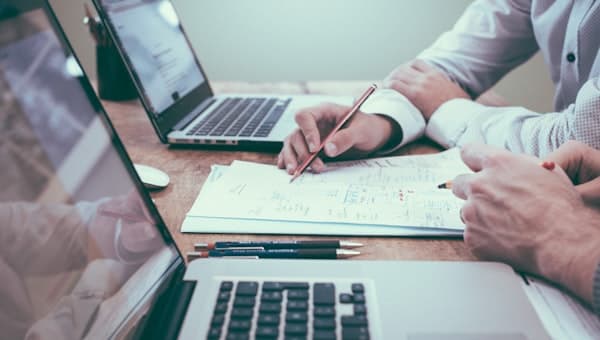 A person reviewing a spreadsheet and notes