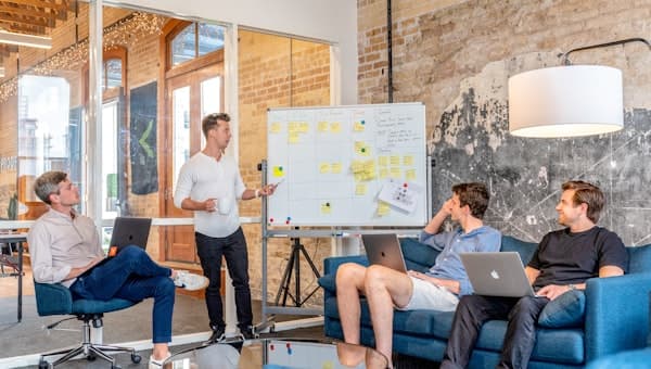A person writing on a whiteboard with the team